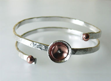 This stunning contemporary sterling silver handcrafted bangle has been made from thick silver wire, forged and formed then complimented with copper. 